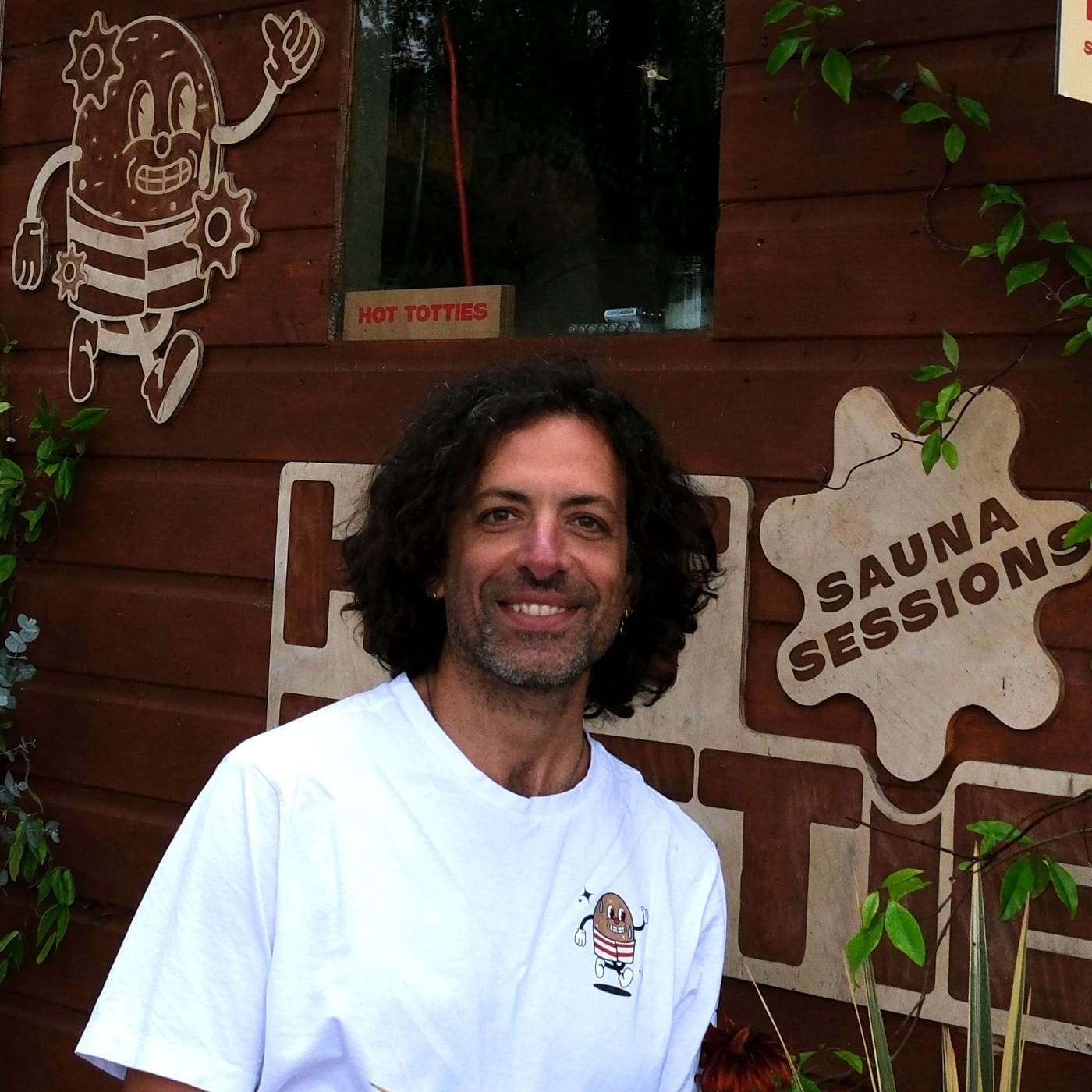 Panos, in a Hot Tottie t-shirt in front of the sauna hut